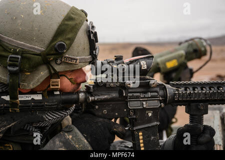 Un soldato di Easy Troop, 2nd Squadron, 11th Armored Cavalry Regiment osserva il paesaggio desertico per veicoli nemici che si avvicinano alla città di Nabran al National Training Center di Fort Irwin il 18 febbraio 2017. Il 2/1 ABCT conduce addestramento di assalto urbano per testare la ricognizione, le abilità di osservazione, la pianificazione tattica e il coordinamento con le unità di armi combinate. Questa rotazione migliora la prontezza per i combattimenti ravvicinati e la cattura di obiettivi urbani in condizioni operative realistiche. Foto Stock
