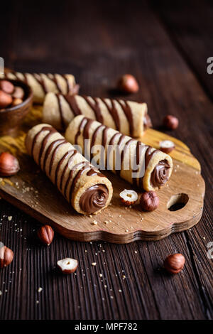 Deliziosi biscotti tubi riempiti con crema di nocciole e cioccolato topping Foto Stock