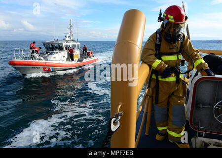 Marinaio Dylan Hankin, un guardacoste membro dell'equipaggio a bordo di coltello pesce spada, controlla il suo lavoro shipmate nella camera del motore come una stazione Port Angeles il suo equipaggio a bordo di un 45-piede Boat-Small risposta seguire la nave torna al molo di Port Angeles, nello Stato di Washington, 6 febbraio 2017. Il 87-Protezione piedi pattuglia di classe equipaggio restituiti alla porta dopo la nave ha registrato una fuoriuscita di olio nella camera del motore. Stati Uniti Coast Guard foto di Sottufficiali di seconda classe Flockerzi Ali. Foto Stock