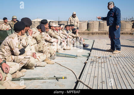 Una delle forze di sicurezza irachene ingegnere, diritto, incarica compagni soldati iracheni durante l assalto di formazione di ponte a Camp Taji, Iraq, Feb 21, 2017. Stati Uniti Soldati addestrati ISF sul ponte di rapida emplacement utilizzando le procedure standard di ponti a nastro a sostegno della Combined Joint Task Force - Funzionamento inerenti risolvere la coalizione globale per sconfiggere ISIS in Iraq e la Siria. (U.S. Esercito foto di Spc. Christopher Brecht) Foto Stock