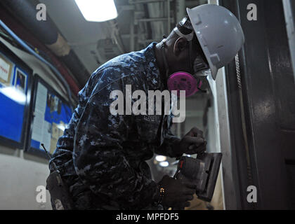 Hospital Corpsman 3rd Class sabbierà un telaio della porta nell'area di attesa medica a bordo della nave ammiraglia USS Blue Ridge (LCC 19) il 22 febbraio 2017. La nave è sottoposta a manutenzione approfondita per modernizzare i sistemi di comunicazione, migliorare le capacità operative e mantenere la preparazione per le missioni regionali. Le attività includono riparazioni a bordo, ammodernamento, manutenzione delle strutture mediche e supporto per le operazioni dell'equipaggio durante periodi di disponibilità limitata nel bacino di carenaggio di Yokosuka, Giappone. Foto Stock