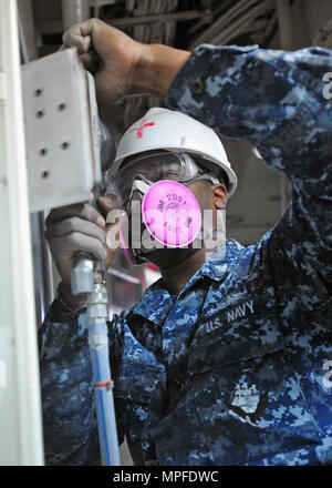 Hospital Corpsman 3rd Class sabbierà un telaio della porta nell'area di attesa medica a bordo della nave ammiraglia USS Blue Ridge (LCC 19) il 22 febbraio 2017. La nave è sottoposta a manutenzione per modernizzare le comunicazioni, migliorare le capacità operative, mantenere la preparazione medica e garantire il supporto dell'equipaggio. Le attività includono riparazioni a bordo, manutenzione delle strutture mediche, aggiornamenti del sistema, controlli di sicurezza e preparazione per le missioni continuative nell'area operativa della 7th Fleet degli Stati Uniti. Foto Stock