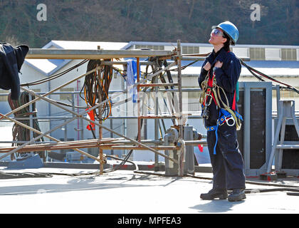 170222-N-YG414-089 Yokosuka, Giappone (feb. 22, 2017) - Cryptologic tecnico (Tecnico) terza classe Rebecca Medrano da Ovilla, TX, fissato per gli Stati Uniti 7 ammiraglia della flotta USS Blue Ridge (LCC 19), comunica a un marinaio lavorando aloft. Blue Ridge è in un esteso intervallo di manutenzione al fine di modernizzare la nave di continuare a servire come una robusta piattaforma di comunicazione negli Stati Uniti 7 flotta area di operazioni. (U.S. Foto di Marina di Massa Specialista comunicazione marinaio Patrick Semales/ rilasciato) Foto Stock