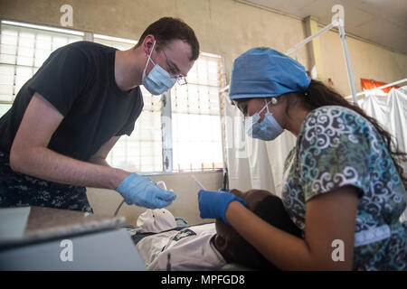 170224-N-WZ792-007 Trujillo, Honduras (feb. 24, 2017) - Hospitalman Lucas Guinon, nativo di Vallejo, California, assegnato a Walter Reed Militare Nazionale Medical Center, Bethesda, Md., assiste una nazione ospite dentista durante una pulizia dentale per il perdurare della promessa 2017 (CP-17) sito medico a sostegno di CP-17's visita a Trujillo, Honduras. CP-17 è un U.S. Comando sud-sponsorizzato e U.S. Forze Navali Comando meridionale/STATI UNITI 4a flotta-condotto di distribuzione condotta civile-militare comprendente le operazioni di assistenza umanitaria, impegni di formazione e medico, dentista e veterinario nel supporto Foto Stock