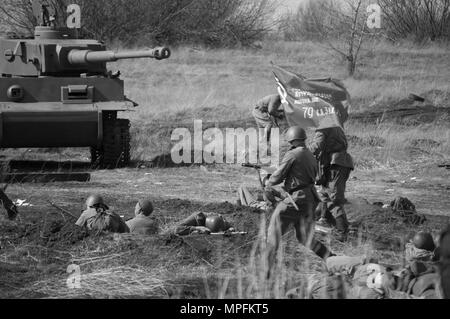 2018-04-30 La regione di Samara, Russia. L offensiva di soldati dell'esercito sovietico con una bandiera sulla posizione delle truppe tedesche. La ricostruzione della Foto Stock