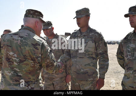 Spc. Alec Fugate con il 207th Constuction orizzontale società riceve una moneta da Briga. Gen. Benjamin Adams III, Kentucky il direttore del personale comune, Mar. 4 durante una visita a Camp Arifjan in Kuwait. Foto Stock