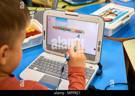 Il bambino impara a codificare. Ragazzino che lavora su un computer portatile con stilo Foto Stock