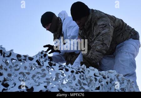 Paracadutisti da Bravo truppa, 1° Stormo, 91º reggimento di cavalleria, 173rd Airborne Brigade impostare le antenne dopo il drappeggio camuffamento invernale sui loro Bandvagn 206 veicoli cingolati nel duro inverno terreno della Norvegia settentrionale durante l'esercizio comune della Viking 17. Comune di Viking 17 è un esercizio combinato a nord del Circolo Polare Artico che prove paracadutisti' capacità di ricognizione e letalità in climi molto freddi ambienti. Foto Stock