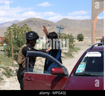 Ghazni, Afghanistan. 22 Maggio, 2018. Una sicurezza afghane stati cerca un uomo in un checkpoint dopo gli attacchi dei talebani su Dih Yak e distretti Jaghato nella città di Ghazni, capitale della provincia di Ghazni, Afghanistan, 22 maggio 2018. Almeno 12 personale di polizia, tra cui due alti funzionari di polizia, sono stati uccisi in nuovi scontri con militanti talebani in Afghanistan orientale della provincia di Ghazni durante la notte, un funzionario locale ha detto martedì. Credito: Sayed Mominzadah/Xinhua/Alamy Live News Foto Stock