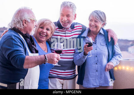 Evento di celebrazione all'aperto per un gruppo di persone adulte. drkinking vino nella terrazza sul tetto con una bella vista sullo sfondo. Lo stile di vita felice togethe Foto Stock