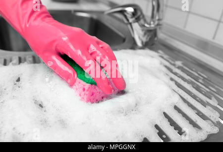 La mano in un guanto di gomma lava il lavandino. Foto Stock