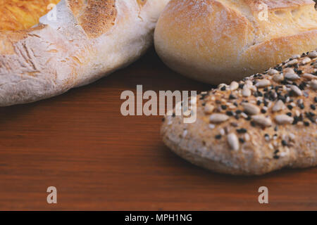 Vari tipi di pane su sfondo di legno. Un sano concetto di pasto Foto Stock