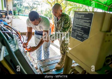 TRUJILLO, Honduras (feb. 24, 2017) - Costruzione elettricista 2a classe Jan-Rainer San Juan, nativo di Fontana, Colo., assegnato al battaglione di costruzione unità mobile (CBMU) 202 distacco, Jacksonville, Florida, treni di una nazione ospite elettricista a la continua promessa 2017 (CP-17) sito medico a sostegno di CP-17's visita a Trujillo, Honduras. CP-17 è un U.S. Comando sud-sponsorizzato e U.S. Forze Navali Comando meridionale/STATI UNITI 4a flotta-condotto di distribuzione condotta civile-militare comprendente le operazioni di assistenza umanitaria, impegni di formazione e medico, dentista, veterinario e assistenza Foto Stock