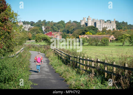 Una donna cammina lungo un sentiero vicino Castello di Arundel in Arundel, West Sussex, Regno Unito. Foto Stock