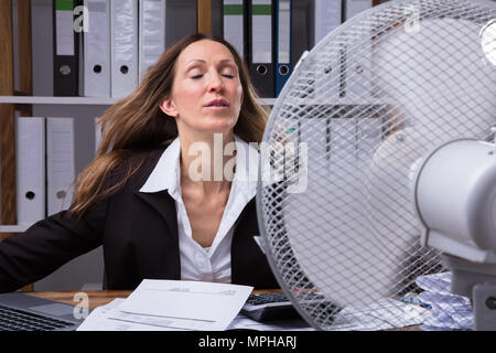 Coppia imprenditrice stessa di raffreddamento nella parte anteriore della ventola durante il tempo caldo Foto Stock