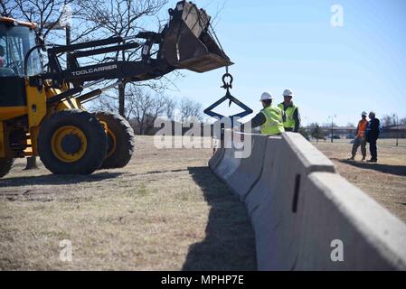 Avieri assegnato alla ventiduesima ingegnere civile Squadron posto ostacoli concreti intorno a un edificio durante un esercizio del 1 marzo 2017, a McConnell Air Force Base, Kan. Avieri deve lavorare rapidamente per completare il progetto, il che significa che esso è di fondamentale importanza che essi lavorano insieme. (U.S. Air Force foto/Airman 1. Classe Erin McClellan) Foto Stock