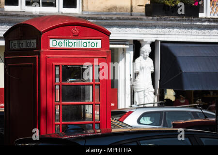 Britannico tradizionale telefono rosso box convertito a un pubblico / street defibrillatore. Montpellier, Cheltenham, Gloucestershire Foto Stock