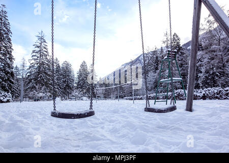 Swing vuota nel periodo invernale con la neve. Foto Stock