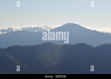 Nuvole che copre le creste della montagna della Cordillera campagna durante la mattina presto vista dal Monte Ulap durante il nostro giorno escursione sull'ECO-trail. Foto Stock