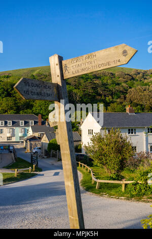 Crooked indicazioni del cartello in legno con le direzioni lungo la costa sud-ovest nel percorso di Lulworth, Dorset, England, Regno Unito Foto Stock