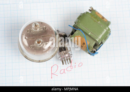Il vecchio tubo a vuoto (electron tube) e del trasformatore sul grafico sfondo della carta Foto Stock