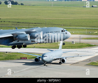 Un Boeing KC-46A Pegasus arriva a Travis Air Force Base in California mentre come C-17 Globemaster III prende il largo, Marzo 7, 2017. Travis è stata selezionata come una posizione preferita per la Air Force del più recente il rifornimento aereo in gennaio. Questa è la prima volta che il velivolo ha volato a una mobilità Aria di comando di base ed è programmato per completare Terra e prova di volo durante il suo tempo a Travis. (U.S. Air Force foto di Luigi Briscese) Foto Stock