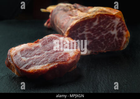 Deliziosa carne di maiale iberico lombata su sfondo nero Foto Stock