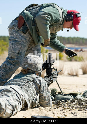 Senior Airman Jeffrey Burton, 436th delle forze di sicurezza Squadron Combat Arms istruttore, si prepara a "asta" la canna della M-249 Macchina di luce essendo Pistola sparato da Airman 1. Classe Annamae Prentiss, 436th SFS response force stati, 9 marzo 2017, a gamma 7 sul giunto di baseGuire-Dix Mc-Lakehurst, N.J. Burton rodded la canna per garantire che fosse libero da qualsiasi ostacolo prima di un cambio di camera sulla M-249. (U.S. Air Force Foto di Roland Balik) Foto Stock