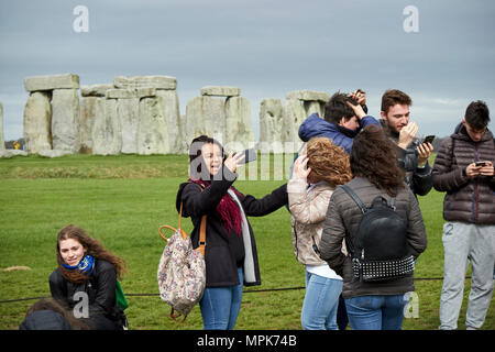 Tour del gruppo di giovani studenti prendere selfies a Stonehenge Wiltshire, Inghilterra Regno Unito Foto Stock