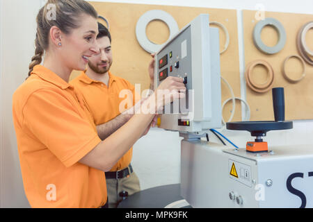 Team di falegnami programmazione macchina CNC nel loro seminario Foto Stock