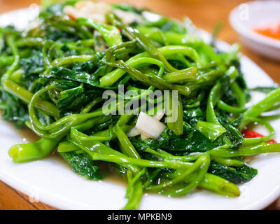 Fritto vietnamita gloria di mattina, rau muong xao toi. Questo è un piatto popolare in ampie parti dell'Asia, realizzato con crescione o acqua spinaci, chili pep Foto Stock