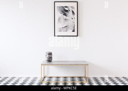 Minimalista in bianco e nero interno dell appartamento per un artista con un lussuoso golden da banco e una cornice per una foto su una parete vuota Foto Stock