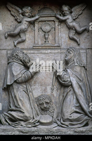 San Girolamo (Stridon, 347-Betlemme, 420). Eremita e dottore della Chiesa. Santa Paula di Roma (347-404). San Romano e precoce madre del deserto. Rilievo raffigurante due santi adorare il Santissimo Sacramento. Sculture di officina dei Leoni, stile barocco. La facciata della chiesa del Monastero del Corpus Domini (Las Carboneras), 1615-1625. Madrid, Spagna. Foto Stock