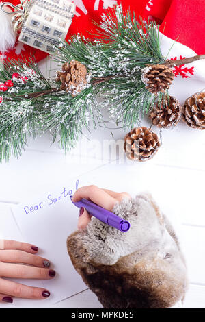 Donna mani iscritto sulla cartolina di Natale, primo piano delle mani Foto Stock