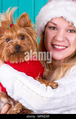 Bella ragazza in santa cappuccio con il cane yorkie in maglione rosso Foto Stock