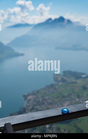Vista del Monte Pilatus, Mt Burgenstock e weggis dal Monte Rigi in Svizzera vicino a Lucerna. Blue pebble a fuoco in primo piano Foto Stock