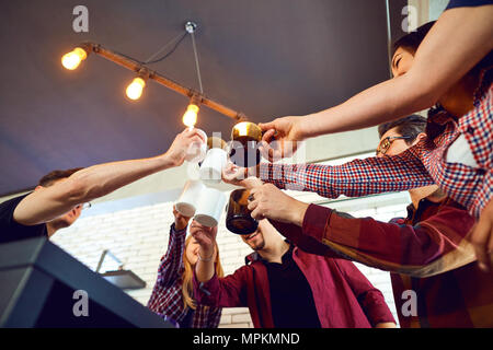 Gli amici hanno alzato la mano verso l'alto con la coppa. Foto Stock