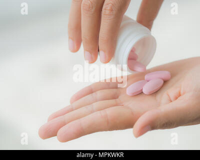 Una giovane donna si effonde medicina nella sua mano Foto Stock