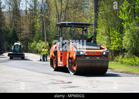 Un rullo su strada o a rullo compattatore, compattazione di asfalto in un parcheggio in speculatore, NY USA Foto Stock