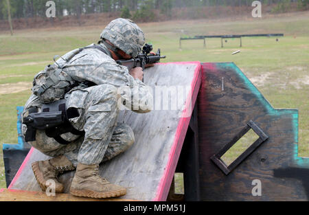 Sgt. 1. Classe Denver Claywell, sede e Sede Società, 1-116th fanteria, Virgina Guardia nazionale, incendi sua M16 fucile da un ostacolo durante un'azione-gara di tiro 18 marzo, un soldato con la precisione di tiro dell'esercito tempi di unità e supervisiona un concorrente durante un'azione-gara di tiro, che era parte del 2017 U.S. Esercito piccole armi campionato "esercito di tutti". L'Esercito di tutto il campionato è stato ospitato dal governo degli STATI UNITI Esercito di unità di precisione di tiro a Fort Benning, Ga., e aperto a tutti i componenti dell'esercito: Active Duty, Guardia nazionale, Riserva e ROTC. (U.S. Foto dell'esercito da Michelle Lunato/rilasciato) Foto Stock