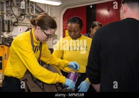 170323-N-BB269-042 Mare delle Filippine (23 marzo 2017) velisti assegnati all'assalto anfibio nave USS Bonhomme Richard (LHD 6) Verificare il bagaglio come parte di una finta di non belligeranza operazione di evacuazione (NEO) nell'hangar bay a bordo della nave. NEO trapani sono eseguite per assicurare Navy e Marine Corps unità possono rapidamente ed efficientemente evacuare, trattare ed elaborare i cittadini americani in una situazione di emergenza se è richiesta assistenza da parte del Dipartimento di Stato. Bonhomme Richard, ammiraglia del Bonhomme Richard Expeditionary Strike gruppo, con avviato 31 Marine Expeditionary Unit, è su di una routine Foto Stock