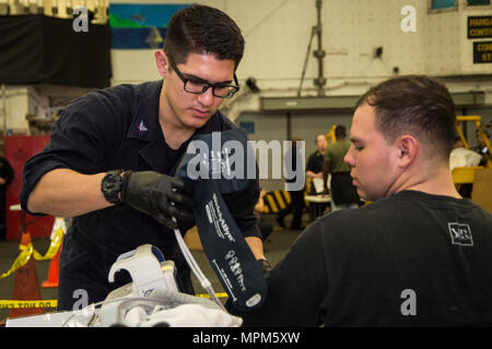 170323-N-BB269-069 Mare delle Filippine (23 marzo 2017) Ospedale Corpsman 3rd Class Martin Salinas, assegnato all'assalto anfibio nave USS Bonhomme Richard (LHD 6), controlli a pazienti con pressione del sangue durante la simulazione di una non belligeranza operazione di evacuazione (NEO) nell'hangar bay a bordo della nave. NEO trapani sono eseguite per assicurare Navy e Marine Corps unità possono rapidamente ed efficientemente evacuare, trattare ed elaborare i cittadini americani in una situazione di emergenza se è richiesta assistenza da parte del Dipartimento di Stato. Bonhomme Richard, ammiraglia del Bonhomme Richard Expeditionary Strike gruppo, con l'EMBA Foto Stock