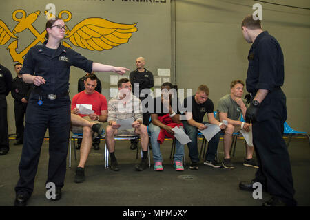 170323-N-BB269-072 Mare delle Filippine (23 marzo 2017) velisti assegnati all'assalto anfibio nave USS Bonhomme Richard (LHD 6) partecipanti diretti durante la simulazione di una non belligeranza operazione di evacuazione (NEO) nell'hangar bay a bordo della nave. NEO trapani sono eseguite per assicurare Navy e Marine Corps unità possono rapidamente ed efficientemente evacuare, trattare ed elaborare i cittadini americani in una situazione di emergenza se è richiesta assistenza da parte del Dipartimento di Stato. Bonhomme Richard, ammiraglia del Bonhomme Richard Expeditionary Strike gruppo, con avviato 31 Marine Expeditionary Unit, è su una routi Foto Stock