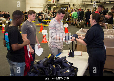 170323-N-BB269-078 Mare delle Filippine (23 marzo 2017) di Boatswain mate 1. Classe Katrina Williams, assegnato all'assalto anfibio nave USS Bonhomme Richard (LHD 6), problemi fuori abbandonare la nave sacchetto-tipo vita conservando le unità per i partecipanti in una simulazione di non belligeranza operazione di evacuazione (NEO) nell'hangar bay a bordo della nave. NEO trapani sono eseguite per assicurare Navy e Marine Corps unità possono rapidamente ed efficientemente evacuare, trattare ed elaborare i cittadini americani in una situazione di emergenza se è richiesta assistenza da parte del Dipartimento di Stato. Bonhomme Richard, ammiraglia del Bonhomme Richard Foto Stock