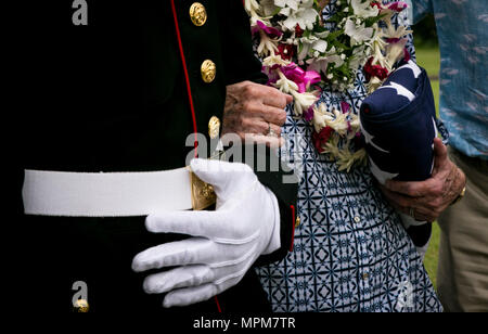 Taff Sgt. Kendrix D. Graham accompagnatrici Nancy Hazelbaker dopo il memoriale di servizio per suo marito, pensionato Marine Col. Vincil W. Hazelbaker, all'Hawaiian Memorial Park Cemetery il 24 marzo 2017. Dopo la cerimonia, elicotteri da Marine Aircraft Group 24 ha condotto un uomo mancante formazione, che è un' antenna salutate eseguite durante un flypast di aereo a un evento commemorativo, tipicamente in memoria di un caduto pilota. Hazelbaker era un aviatore marino che ha servito nei militari per 34 anni. Durante il suo servizio, ha volato più di 680 missioni di combattimento e si è guadagnato la traversa di marina per la sua straordinaria egli Foto Stock