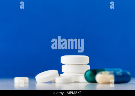 Mazzetto di bianco e pillole colorate. Sparse in pillole. Foto Stock