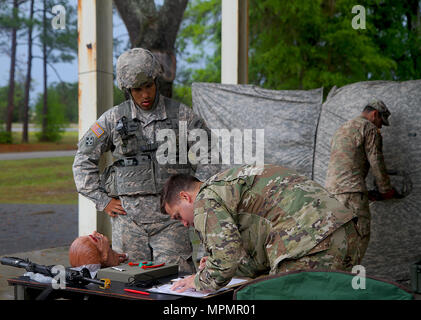 Un U.S. Esercito Nazionale soldato di guardia dal 2° Battaglione, 124reggimento di fanteria si erge da come egli compie uno dei test medici all'esperto di fanteria qualifica di badge a Camp Blanding Training Center, Starke, Fla. il 4 aprile 2017. I soldati si prevede di terminare ciascuna stazione in modo tempestivo. La loro conoscenza di primo aiuto potenzialmente in grado di salvare una vita. (U.S. Esercito foto di Sgt. Garrett Savage) Foto Stock