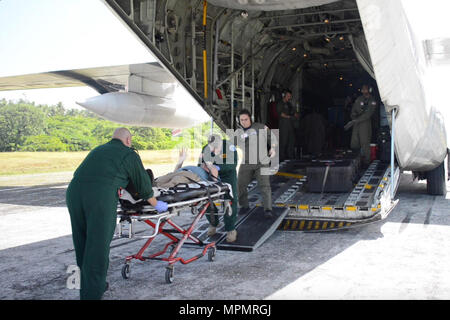 Coast Guard il suo equipaggio assistere i servizi di emergenza il personale di trasporto di un paziente al Queens Medical Center dalla guardia costiera Stazione aria Barbieri punto, Oahu, 4 aprile 2017. Il 74-anno-vecchio uomo arrivò in condizione stabile a Honolulu dopo essere stata medicalmente evacuati da un HC-130 Hercules aereo ad ala fissa 1.061 miglia da atollo Palmyra. (U.S. Coast Guard foto di Sottufficiali di terza classe Amanda Levasseur/rilasciato) Foto Stock