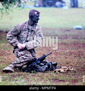 Un soldato con il 2-124esimo reggimento di fanteria, completa la porzione di mimetizzazione di pattuglia test per l'esperto di fanteria qualifica di badge a Camp Blanding Training Center, Starke, Fla. il 5 aprile, 2017. I soldati sono attesi per il camuffamento non solo per se stessi ma anche tutte le apparecchiature in un modo efficiente. (U.S. Esercito foto di Sgt. Garrett Savage) Foto Stock