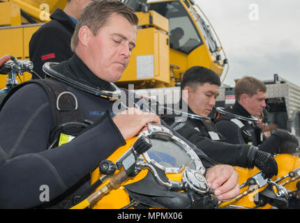 Builder di 2a classe di David Perryman, assegnato alla costruzione subacquea Team (UCT) 2, prepara i suoi diving casco prima di un immersione combinato con un membro della Repubblica di Corea (ROK) UCT in Jinhae, Rok, durante l'esercizio puledro Eagle Aprile 5, 2017. Puledro Eagle è un annuale bilaterale esercizio di formazione progettate per migliorare la disponibilità degli Stati Uniti e le forze di Rok e la loro capacità di lavorare insieme durante una crisi. I marinai di costruzione Dive distacco Charlie sono sulla seconda tappa della loro distribuzione dove sono le ispezioni, manutenzione e riparazioni di varie subacquea e waterfro Foto Stock